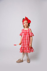 Funny smiling baby girl summer dress  on white background . Baby girl with a lip accessory on a stick.