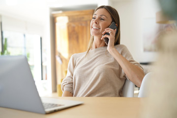 Young woman at home talking on phone