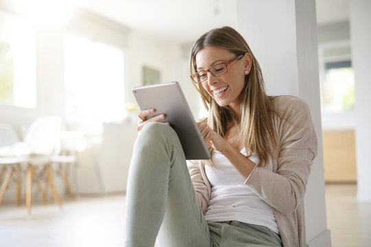 Woman at home relaxing and websurfing with digital tablet