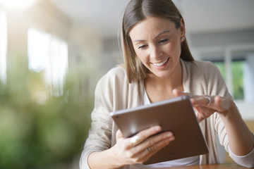 Portrait of woman at home connected with digital tablet