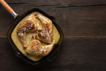 Fried chicken legs in a pan, rustic style, top view