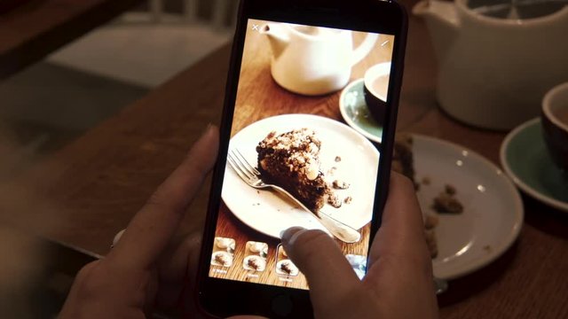 Female takes photo of cake on mobile phone