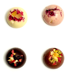 Handmade chocolate candies with a variety of dried fruit and nut toppings