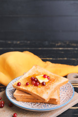 Tasty toasted bread with honey, butter and berries on plate
