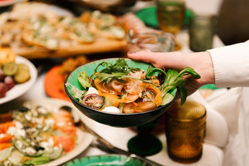 Salad with vegetables, herbs and cheese the waiter puts on the table