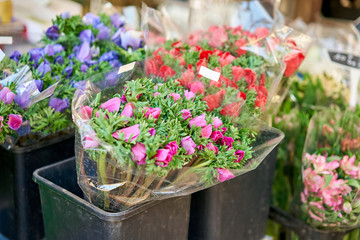 Bunches of different colorful flowers in buckets on street flower market in Anemone, poppy