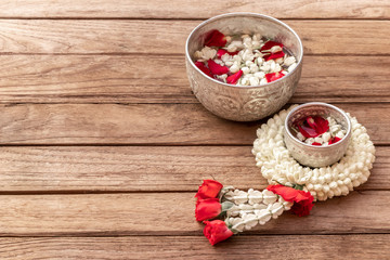 Beautiful thai traditional jasmine garland and rose flower in water bowls. Water in bowl mixed with...