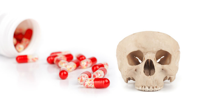 red pills and human skull isolated on a white