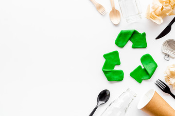 Green recycle icon near plastic, paper, glass waste on white background top-down copy space