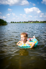 Fototapeta na wymiar child learns to swim. child swims in a swimming circle