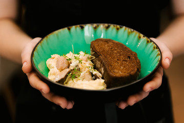 Scramble plate of eggs and bread in hand, selective focus