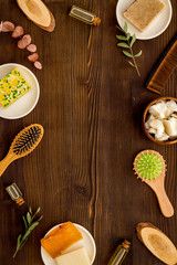 Hair care concept. Coconut oil, brush on dark wooden background top-down frame copy space