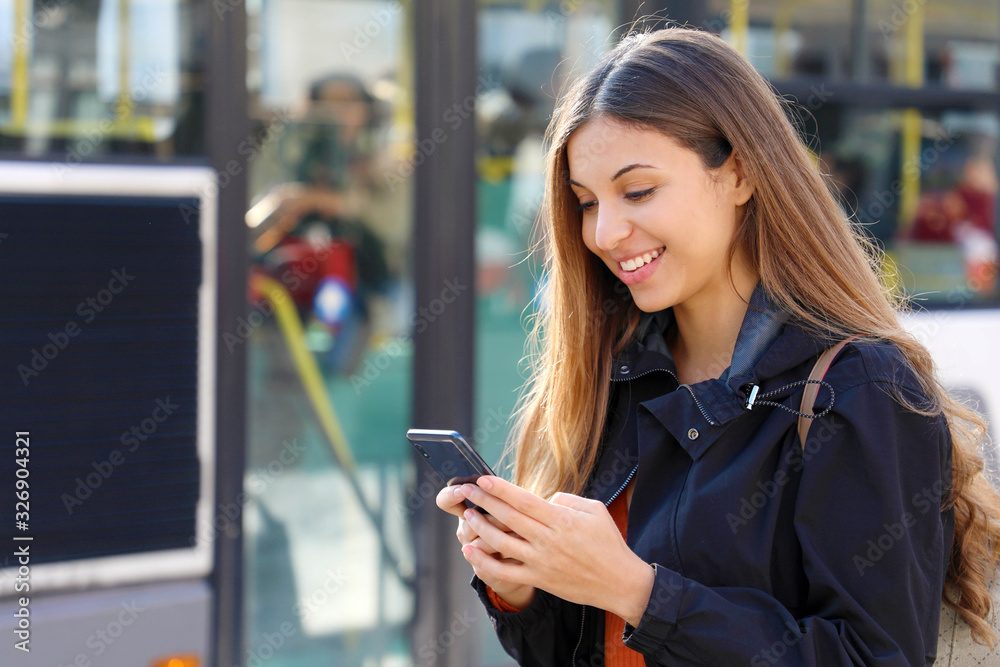 Canvas Prints Young woman buying bus ticket online for city smart transportation. Happy beautiful student girl paying electronic ticket with smart phone app.