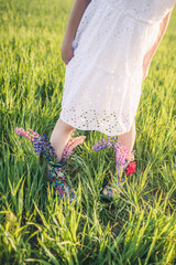 Creative bouquet of flowers in green boots on the green grass.