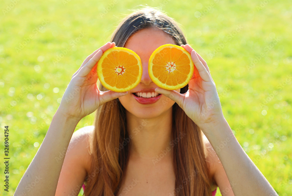 Wall mural funny vitamin c girl. portrait of joyful pretty lovely positive natural young woman hiding behind tw