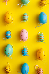 Easter colored eggs on yellow background. Happy Easter greeting card minimal concept. Top view, flat lay