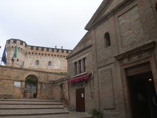 Fototapeta na wymiar entrance of Gradara fortress and the facade of the church of San Giovanni Battista