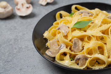 Italian fettuccine pasta with mushrooms, Parmesan cheese and cream sauce, selective focus. 