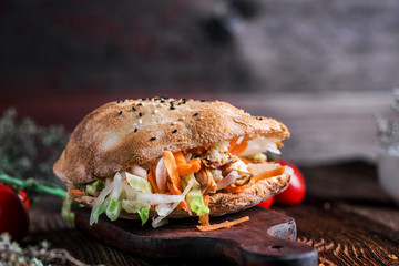 Fresh doner kebab with salad and vegetables served on a rustic wooden plate