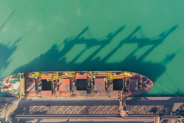 A bulk carrier stands at the berth of a coal terminal in the seaport, cargo is being loaded from an...