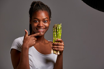 Young woman of African traits posing with fruits and vegetables