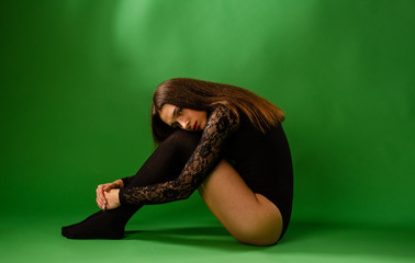 girl in black bodysuit on green background