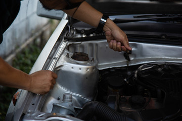 Men are using hands to change the car engine oil to extend the service life.