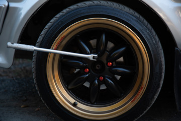 A man using a hand to change a wheel because of a tire bomb