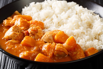 Domoda is the national dish of Gambia, a peanut stew made with meat pumpkin and served over fluffy rice close-up in a plate. Horizontal 