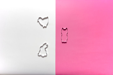 Shapes and stencils of Easter bunny rabbit and chick on pink and white background.