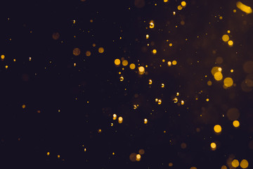 Fototapeta na wymiar Dark Abstract Gold bokeh sparkle on black