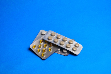 Pills in a blister at classic blue background with copy space