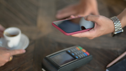 Cropped shot of customer using smartphone to online payment