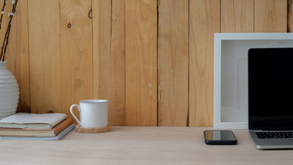 Close up view of workplace with laptop, smartphone, decorations and copy space on wooden table