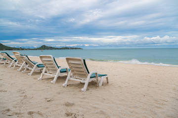Rows of sun bed at sand beach for relaxing with tropical beach and sea
