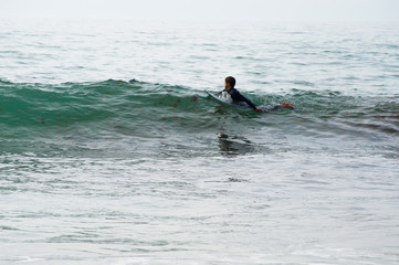 Um surfista a procurar a felicidade na linha do horizonte, enquanto rema por águas cristalinas