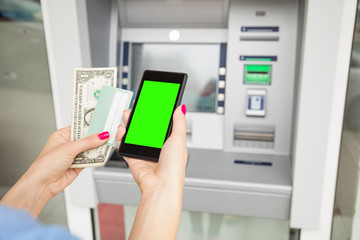 Woman using modern ATM nashine - cash withdrawal.