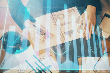 Multi exposure of hands making notes with forex chart huds. Stock market concept.