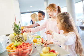 Kinder holen sich frisches Obst am Büffet