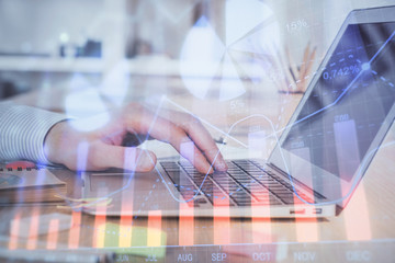 Double exposure of stock market graph with man working on laptop on background. Concept of financial analysis.