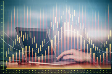 Double exposure of stock market graph with man working on laptop on background. Concept of...