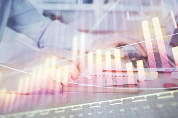 Multi exposure of financial graph with man works in office on background. Concept of analysis.