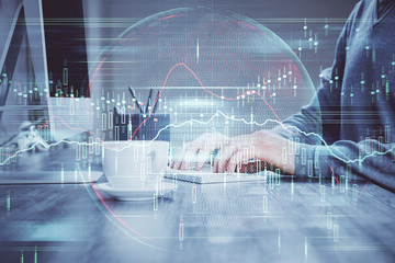 Multi exposure of graph with man typing on computer in office on background. Concept of hard work.