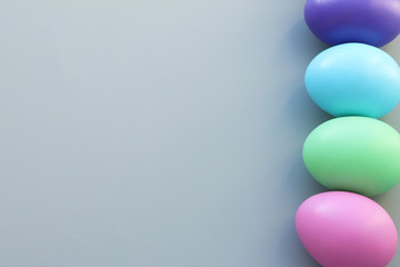 Festive Easter background. Multicolored Easter eggs in a row on a gray background. Selective focus. Copy space
