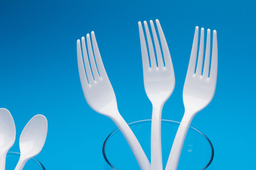 Teaspoon and plastic fork and glass tumbler