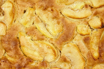 Apple pie, dessert from stewed fruits, closeup, texture, background, top view. Charlotte, homemade baking