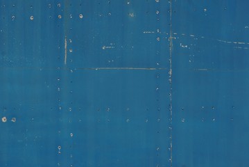 blue background from an old iron wall with gray scuffs and a seam