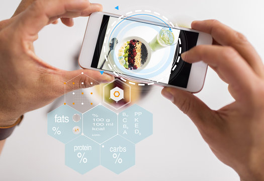 food, eating and technology concept - hands with picture of breakfast on smartphone screen and nutritional value chart