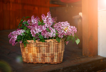 spring bouquet of tulips and lilac in a wicker basket