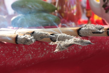 Close up of burning joss sticks with smoke flew in the air. Chinese way of praying for god and make...